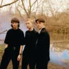 The three members of the band headboy standing beside a river