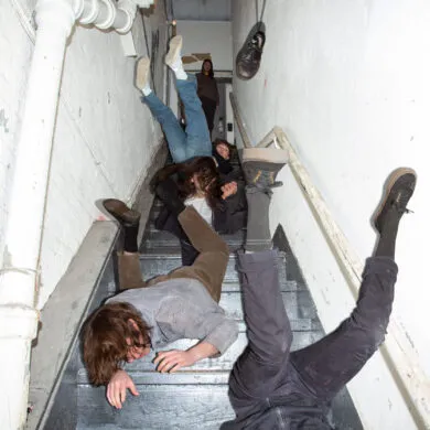 The members of the band Geese, falling down the stairs