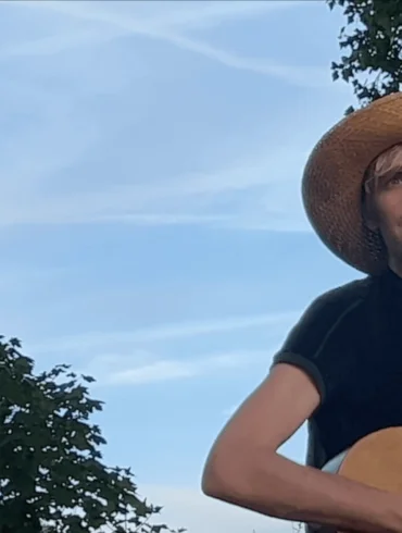 In Conversation: PREGOBLIN 23 Alex Sebley from Pregoblin wearing a straw hat and holding a guitar.