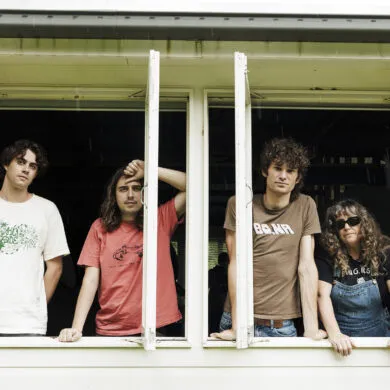 The four members of the band Girl and Girl looking out a window